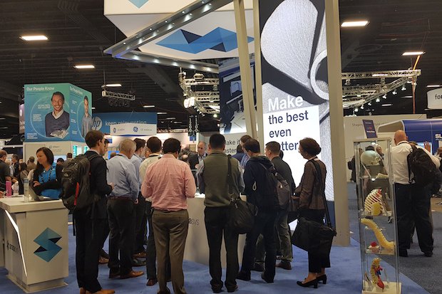 Stratasys metals RAPID + TCT 2018      A crowd gathers around a display of aluminium parts manufactured with Stratasys' metal 3D printing technology.