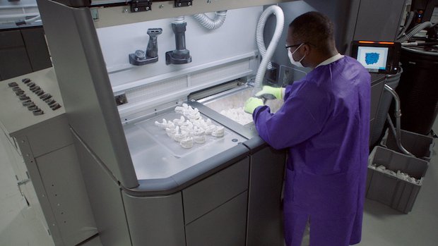 SmileDirectClub staff depowdering aligner moulds printed with HP's Multi Jet Fusion technology. - HP/SmileDirectClub