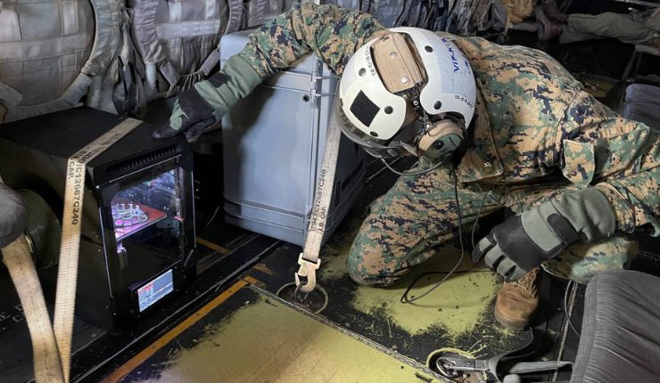 U.S. Marine Corps Lt. Col. Michael Radigan checks on the 3D printing of a medical cast aboard an MV-22 Osprey from Marine Medium Tiltrotor Squadron (VMM) 164 during a training flight - Nav...