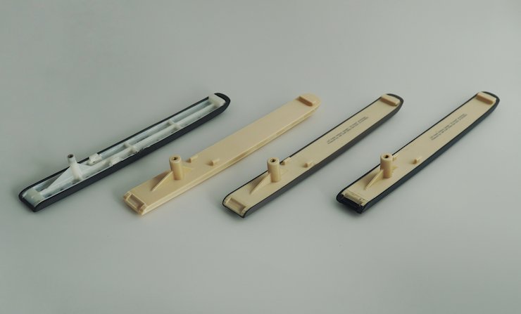 Bottom view of arm caps showing (left to right) the part being replaced, the unpainted 3D printed equivalent, and two colours of the final printed part. - AM Craft