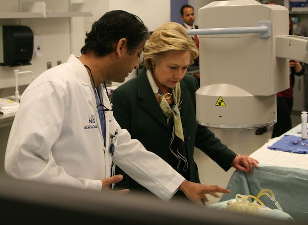 Hillary Clinton with Dr. Adnan H. Siddiqui, Chief Medical Officer, The Jacobs Institute examining 3D printed model.