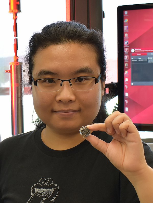 UMass Amherst Ph.D. student Jie Ren holds a miniature heatsink fan, one of the 3D printed high-entropy alloy components made in Wen Chen's lab.